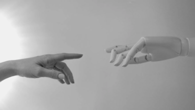 image of a human reaching out touching a robot hand to signify ai chatbot